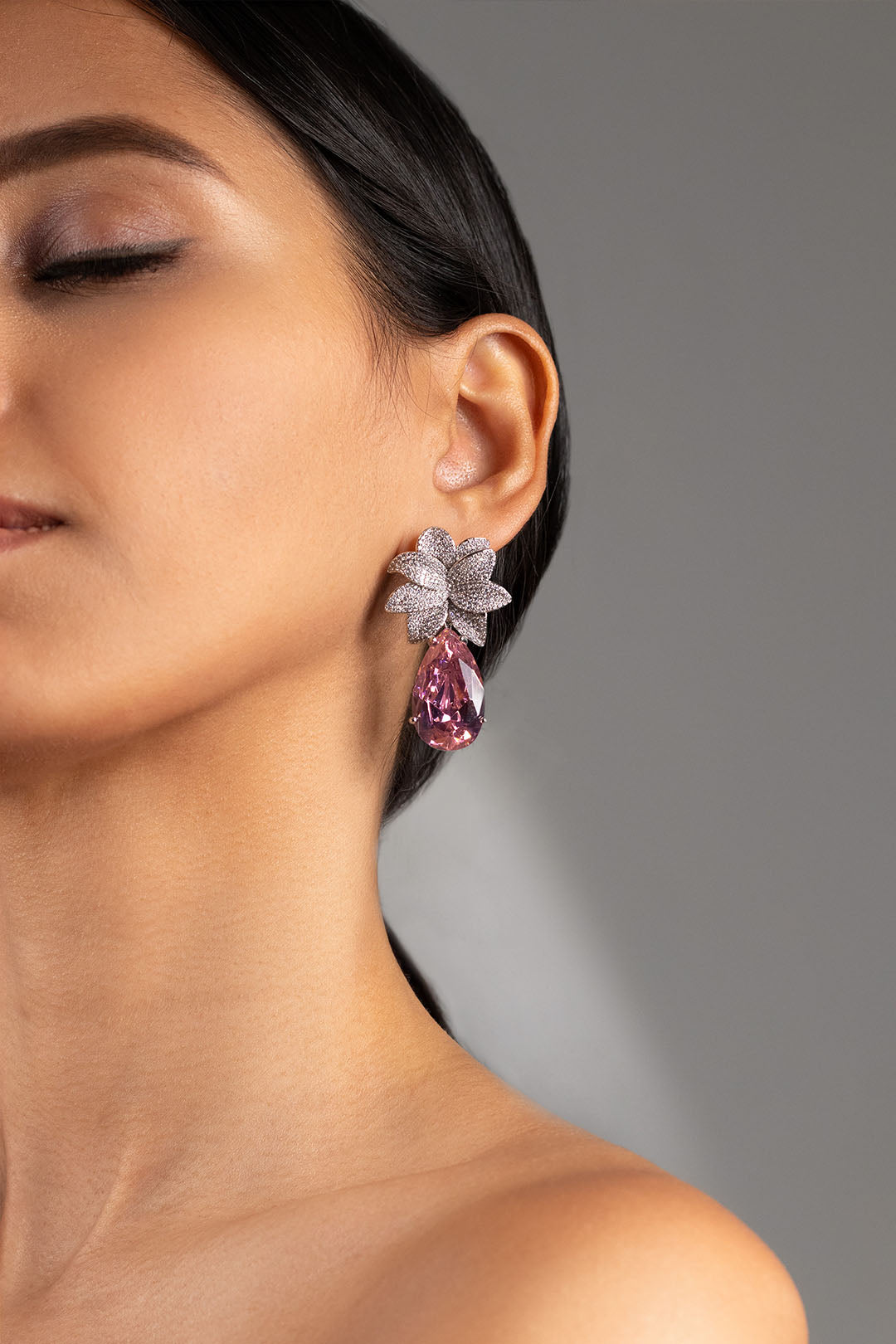 Pink teardrop crystal drop earring with crystal floral stud worn on model's ear – Duavaa