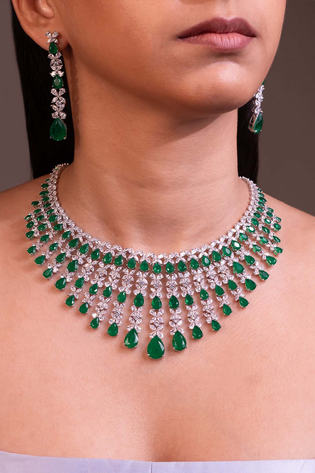 Emerald green pear-drop fringe necklace and earring set worn on model – Duavaa