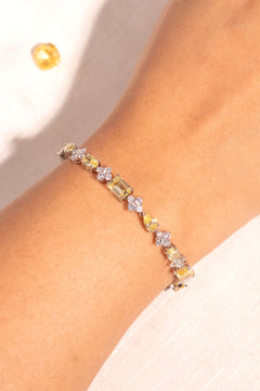 Yellow mixed-cut crystal tennis bracelet with clear floral accents worn on wrist – Duavaa