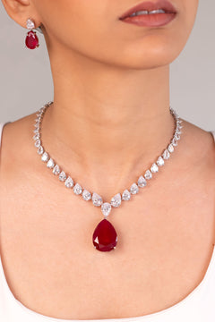 Ruby red teardrop pendant necklace and matching earrings set worn by a model – Duavaa
