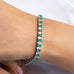 Emerald green and clear pear-cut tennis bracelet worn on a model's wrist – Duavaa