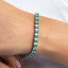 Emerald green and clear pear-cut tennis bracelet worn on a model's wrist – Duavaa