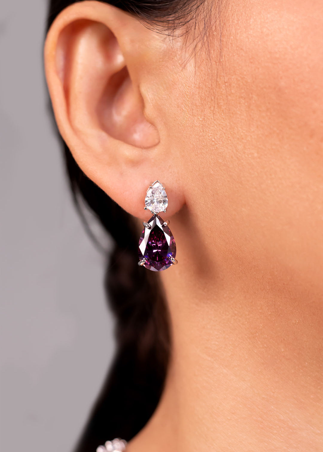 Purple pear-cut crystal drop earrings worn on the ear – Duavaa