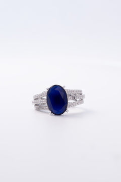 Sapphire blue crystal ring with a vivid centrepiece and pavé bands worn on the finger – Duavaa