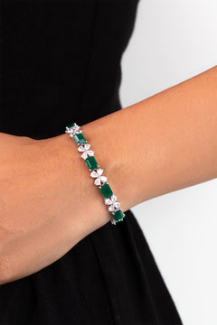 Emerald green emerald-cut stones with floral CZ tennis bracelet worn on a model's wrist – Duavaa
