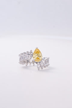 Golden yellow pear-cut crystal ring framed with brilliant stones worn on the finger – Duavaa