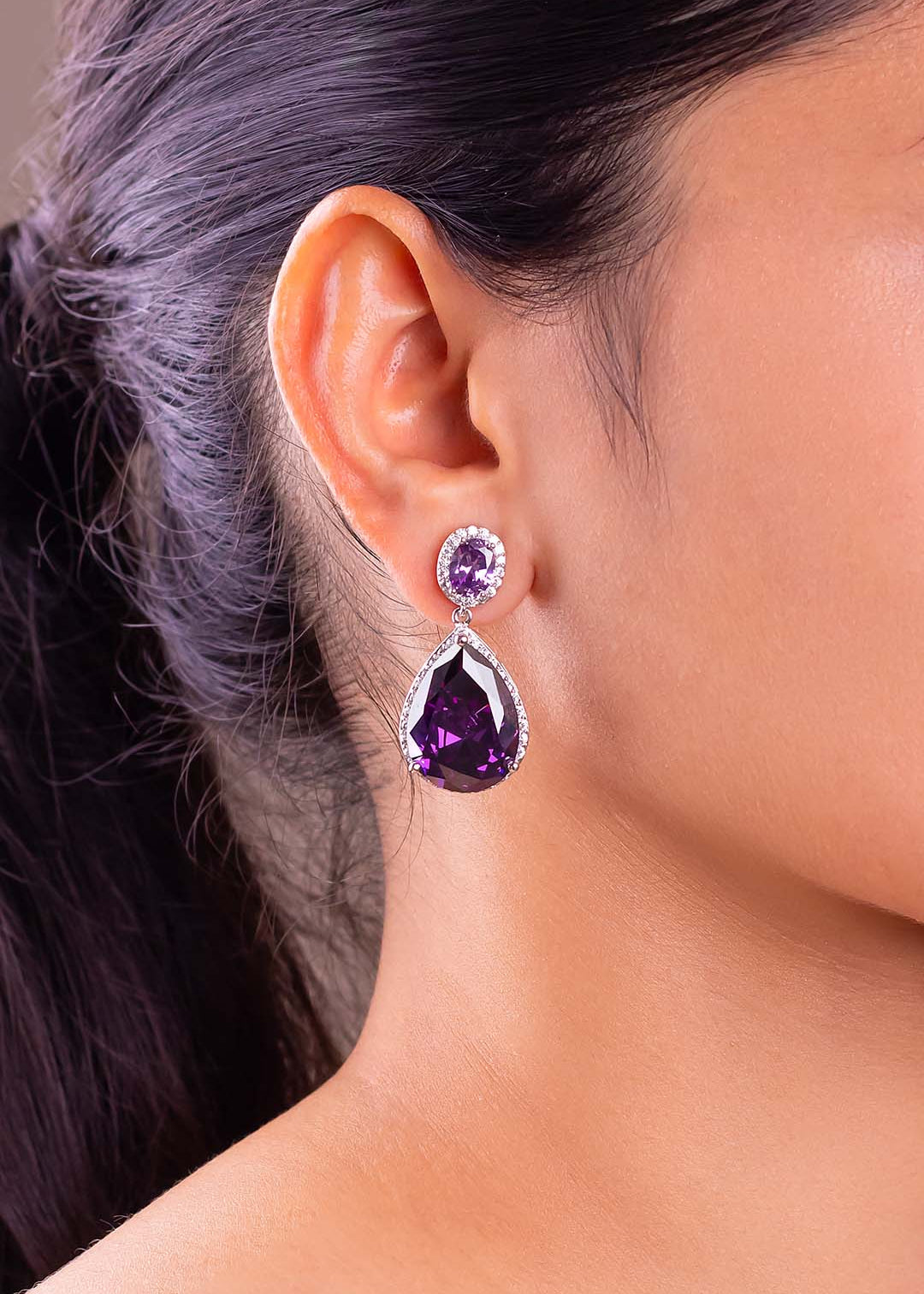 Purple teardrop crystal halo drop earring worn on a model's ear – Duavaa