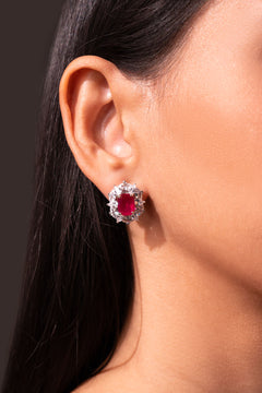 Red ruby-toned stud earring framed by clear CZ halo worn on a model's ear – Duavaa