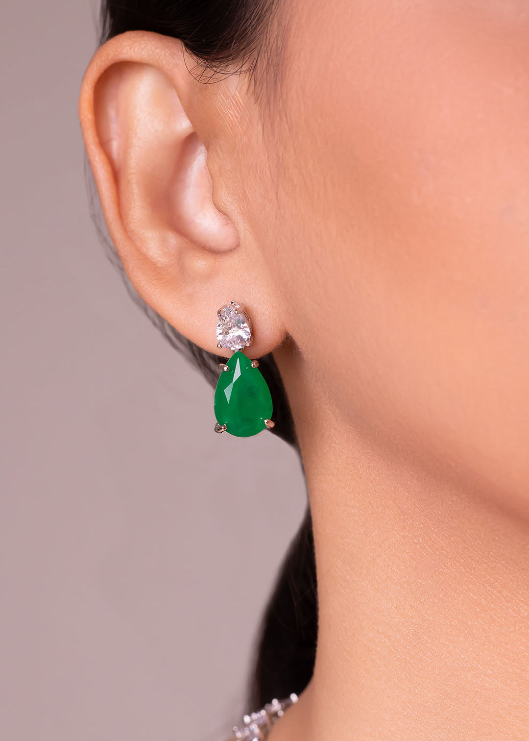 Green pear-cut crystal drop earrings worn on the ear – Duavaa