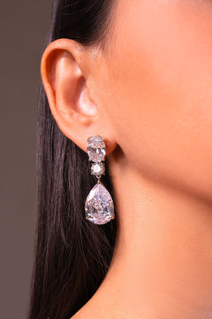 Clear crystal pear drop earring worn on a model's ear – Duavaa