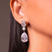 Clear crystal pear drop earring worn on a model's ear – Duavaa