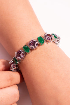 Emerald green and purple oval-cut tennis bracelet with crystal accents worn on the wrist – Duavaa