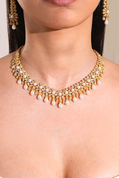 Gold-tone crystal and pearl floral collar necklace with teardrop pearl fringe worn on model, close-up – Duavaa