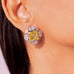 Close-up of yellow square-cut CZ halo stud earring worn on a model's ear – Duavaa