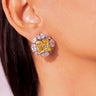 Close-up of yellow square-cut CZ halo stud earring worn on a model's ear – Duavaa