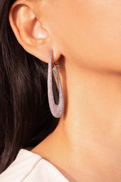Silver pavé crystal elongated oval hoop earring worn on ear – Duavaa