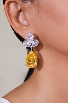 Golden yellow teardrop crystal drop earring worn on model's ear – Duavaa