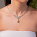 Close-up of silver-tone V-shaped CZ necklace with yellow pear-cut teardrop drop worn on neckline – Duavaa